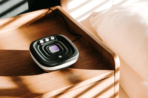 Photo of the Bide device on a wooden bedside cabinet.