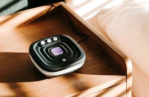 Photo of the Bide device on a wooden bedside cabinet.